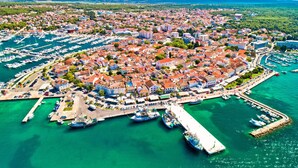 A coastal town with a marina, buildings, and clear blue waters. - Villa Dalmatia Luxury Stone Villa With Pool & Tennis (Sveti Filip i Jakov)