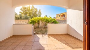 An open balcony with a view of a garden and a building. - Budoni Beach Homes (Budoni)