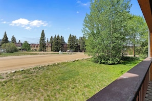 A residential area with a grassy lawn, a dirt path, and a row of multi-story buildings with a clear sky. - Hi Country Haus Unit 2301 Spacious 2 bed, ground floor, walk to downtown (Winter Park)