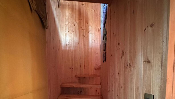 A wooden staircase with a handrail, leading to a higher level.