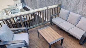 Una terraza con sofá, sillas y una mesa.