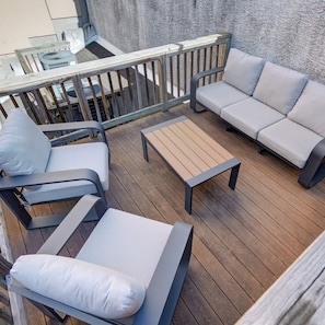 Eine Terrasse mit einer Sitzecke, Sofas und einem Tisch.