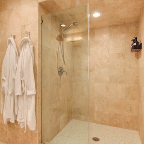 Eine Duschkabine mit Handbrause und verstellbarem Wasserhahn an der Wand.