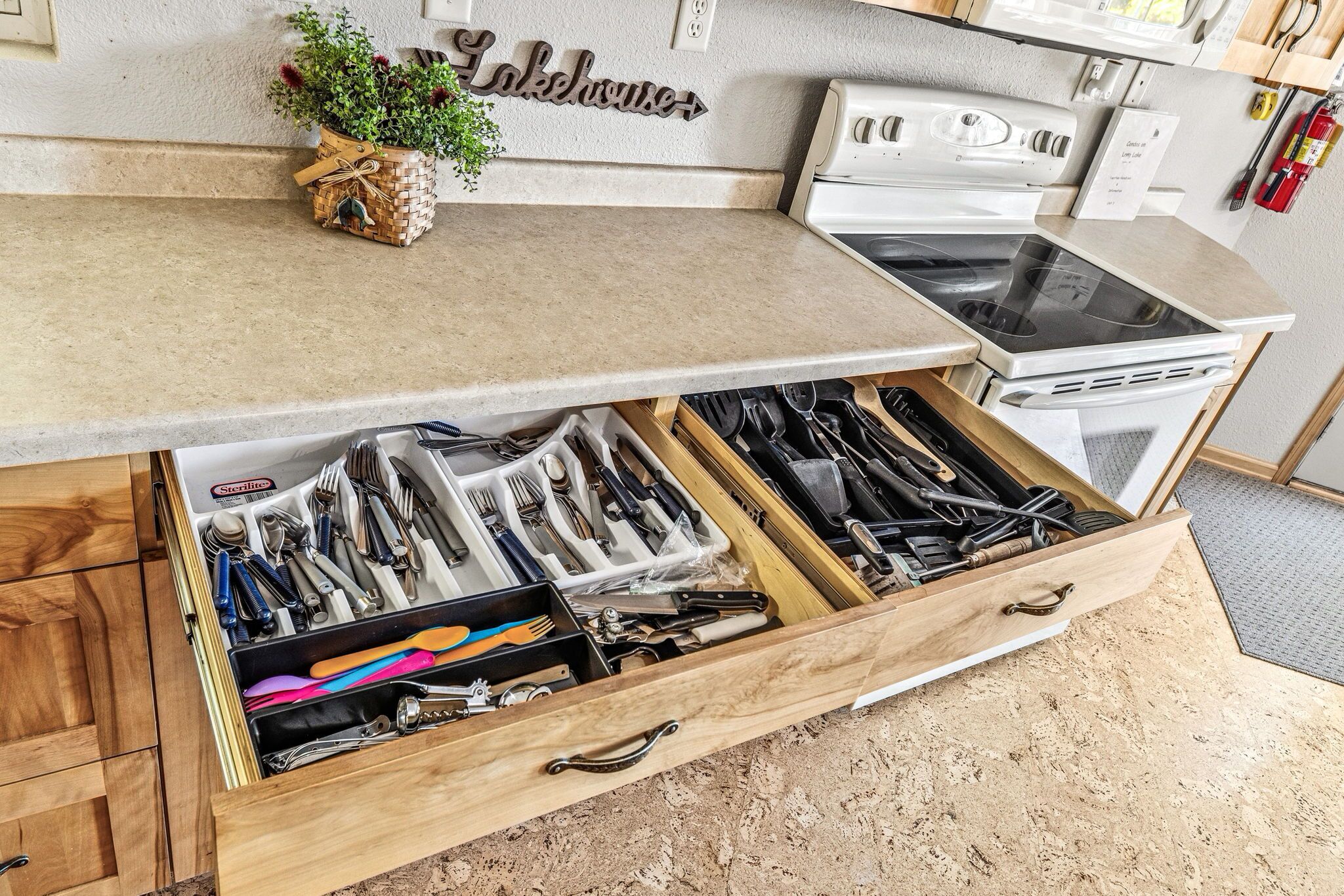 A kitchen with a drawer organizer containing various utensils.