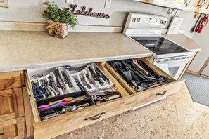 Een keuken met een lade-organizer vol verschillende keukengerei.