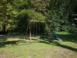 Ein Park mit Schaukeln und einer Rutsche.