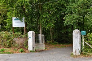Una entrada cerrada con portón metálico a una propiedad llamada 'Le Domaine de la Ferme de Fourges', con un cartel indicador.