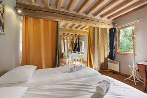 A room with a bed, a table, and a window.