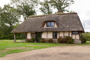 A thatched-roof cottage with a small window, a door, and a stone foundation. - The Cottage – In the Heart of a 20-Hectare Estate (Flancourt-Crescy-en-Roumois)