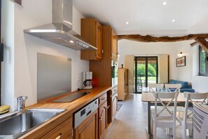 Une cuisine moderne avec des meubles en bois, un évier en acier inoxydable et un four encastré.