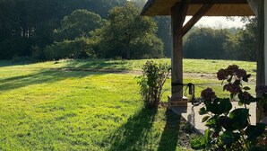 A gazebo with a thatched roof overlooking a grassy field with trees in the background. - The Cottage – In the Heart of a 20-Hectare Estate (Flancourt-Crescy-en-Roumois)