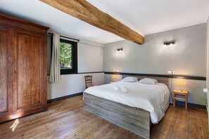 A bedroom with a wooden bed, a nightstand, a wooden wardrobe, and a window with curtains. - La Longère – In the Heart of a 20-Hectare Estate (Flancourt-Crescy-en-Roumois)