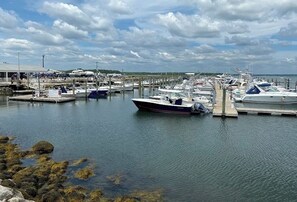 Un port de plaisance avec des bateaux amarrés aux quais, une eau calme et un ciel dégagé.