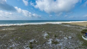 A beach with a clear sky, a sandy area, and a grassy field. - Phoenix Vii 7501 3 Bedroom Condo (Orange Beach)