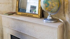 A fireplace mantel with a framed mirror and a globe.