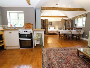 A kitchen with a stove, oven, and a dining area with a table and chairs.