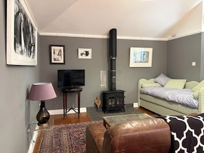 A living room with a television, a fireplace, a sofa, and a coffee table. - The Old Dairy (Warminster)