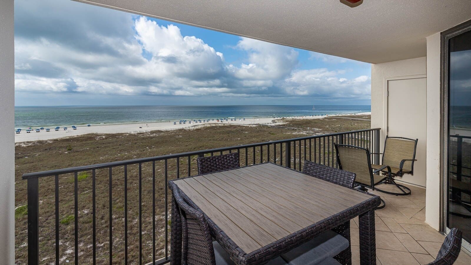 A balcony with a view of a beach and ocean.