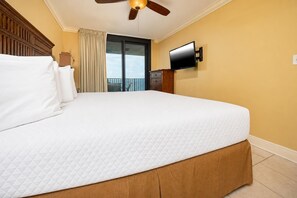 Ein Hotelzimmer mit einem großen Bett, einem Deckenventilator, einem Fernseher und Blick ins Freie.