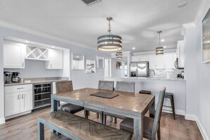 A modern kitchen with white cabinetry, a central island, and pendant lighting. - 🌞Direct Beach Access🌴Heated Pool🐠Sunset Views☀Seagate 407 (Indian Shores)