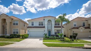 A residential neighborhood with single-story houses, a central driveway, and a well-maintained lawn. - Wh7754 - 6BR House With Pool Near Disney (Kissimmee)