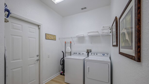 A laundry room with two washing machines, a drying rack, and a vacuum cleaner. - Wh7754 - 6BR House With Pool Near Disney (Kissimmee)
