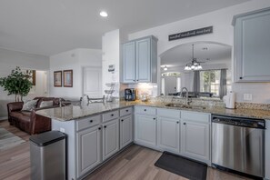 A modern kitchen with light blue cabinets, stainless steel appliances, and a granite countertop. - Wh2584 - 6BR House With Pool Near Disney Parks (Kissimmee)