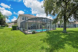 A house with a glass-enclosed patio and a swimming pool. - Wh2584 - 6BR House With Pool Near Disney Parks (Kissimmee)