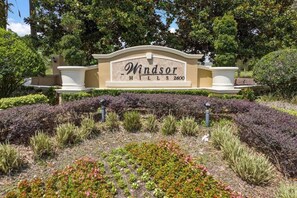 A landscaped sign with the text "Windsor Hills 2600" surrounded by various plants and shrubs. - Wh2584 - 6BR House With Pool Near Disney Parks (Kissimmee)