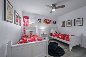 A bedroom with two beds, a ceiling fan, and Mickey Mouse-themed decor. - Wh2584 - 6BR House With Pool Near Disney Parks (Kissimmee)