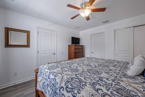 A bedroom with a bed, a ceiling fan, a dresser, a television, and white doors. - Wh2584 - 6BR House With Pool Near Disney Parks (Kissimmee)