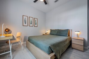 A bedroom with a bed, bedside tables, a chair, and wall-mounted lamps. - Is1-208 - 3BR Condo Near Disney With Lake View (Orlando)
