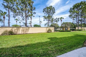 A well-maintained grassy area with tall trees and a clear sky. - Th155 - 3BR House Near Disney, Sleeps 8 Guests (Orlando)