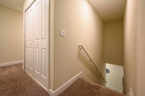 A carpeted hallway with a white door and a handrail leading to a landing. - Sl4802 - 4BR House With Pool Near Disney Area (Kissimmee)