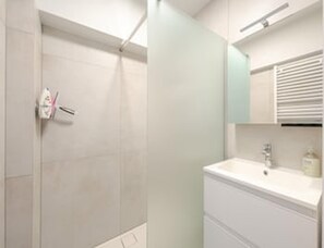 A bathroom with a shower, a sink, and a mirror. - Blankenberge Apartment for 4 (Blankenberge)