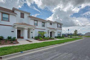 A row of white houses with brown trim and tiled roofs, arranged in a residential street. - Sl4926 - 4BR House With Pool Near Disney Area (Kissimmee)