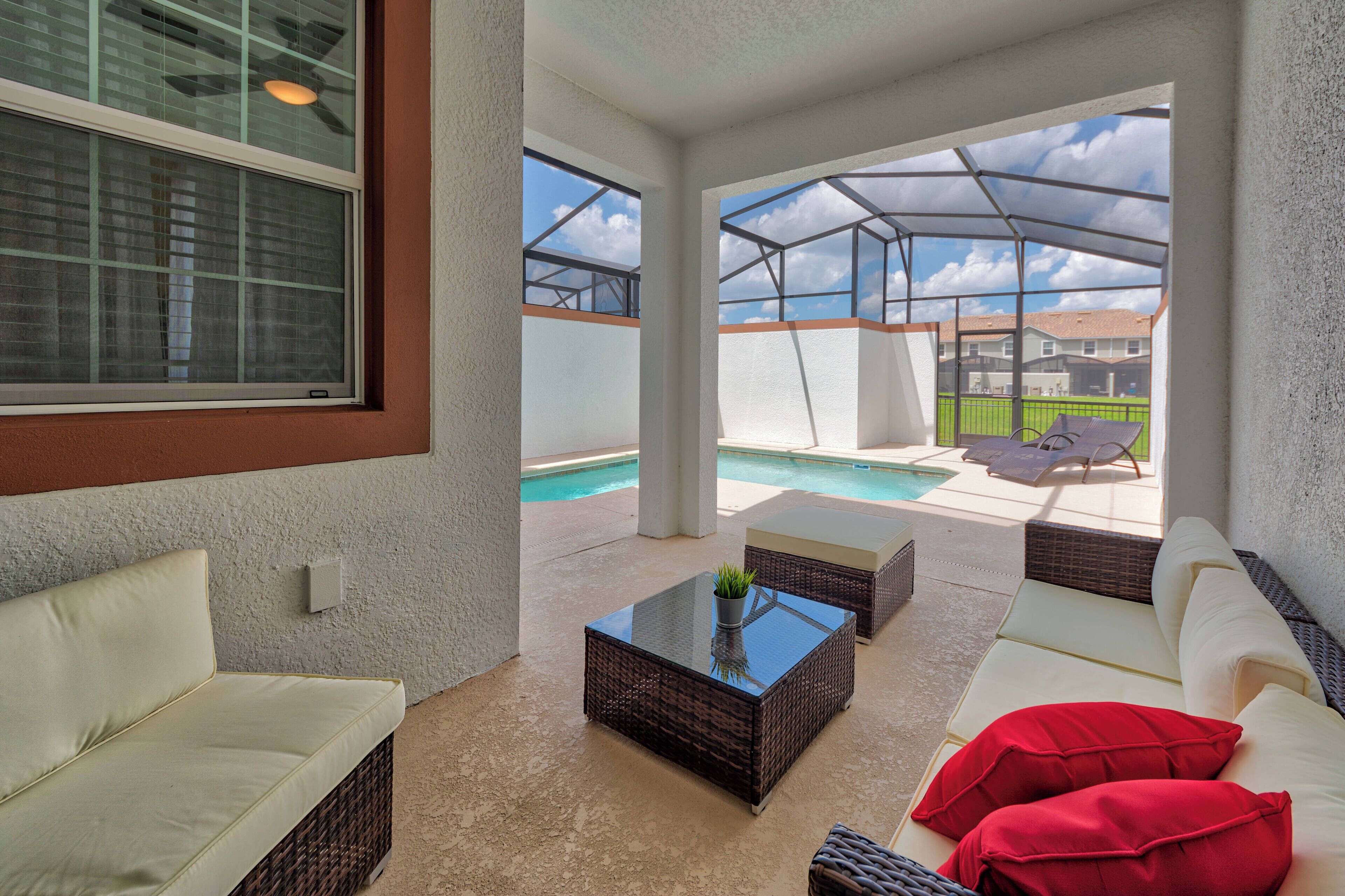 Ein überdachter Patio-Bereich mit Pool, Sitzgelegenheiten im Freien und Blick auf den Pool.