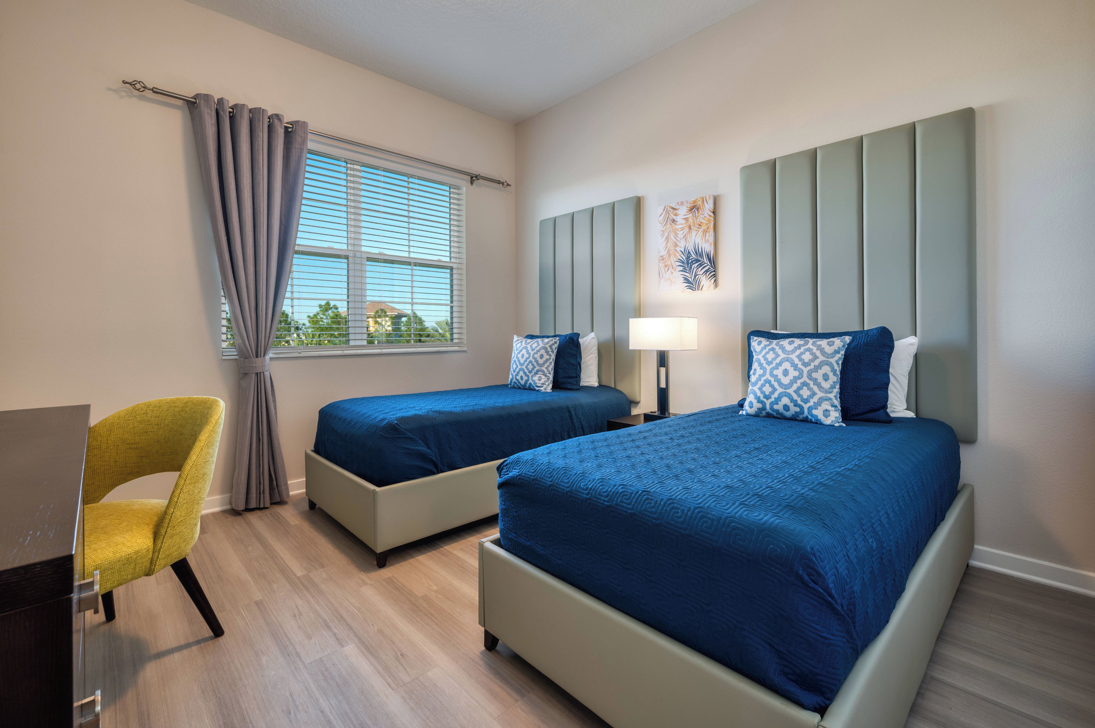 Habitación de hotel con dos camas, un escritorio y una silla.