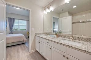 A modern bathroom with a large mirror, two sinks, and a vanity. - Vcr4-404 - 3BR Condo w/ Resort Access Near Disney (Orlando)