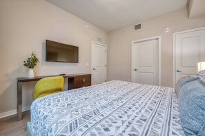 A bedroom with a bed, a desk, a chair, a television, and two doors. - Vcr2-310 - 3BR Condo Near Disney and Universal (Orlando)