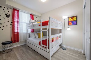 A bunk bed room with a red and white color scheme, a standing lamp, and a wall with cartoon characters. - Sl3111-106 - 2BR Apartment Near Disney Attractions (Kissimmee)