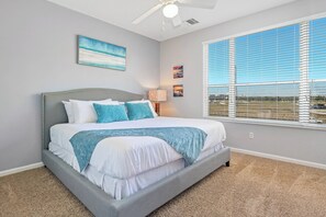 A bedroom with a bed, a ceiling fan, a window with blinds, and artwork on the walls. - Th130 - 3BR House Near Disney and Universal Parks (Orlando)