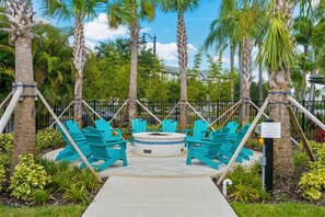 Zona con fogata, sillas Adirondack turquesas y disposición circular para sentarse.