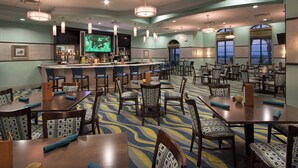 A hotel dining area with multiple tables and chairs, a bar, and large windows providing views. - Cg1569 - 5BR House With Pool Near Disney Parks (Davenport)