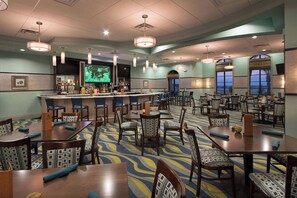 A hotel dining area with multiple tables and chairs, a bar, and large windows providing views. - Cg1569 - 5BR House With Pool Near Disney Parks (Davenport)