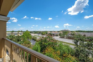 A residential area with a clear blue sky, a road, and buildings in the distance. - Vc14-407 - 2BR Epic Condo Near Disney (Orlando)