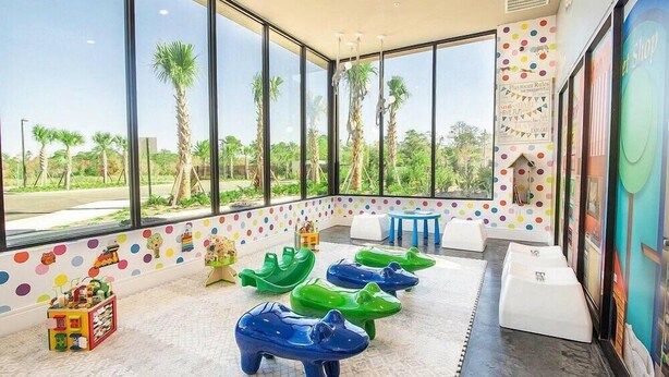 A children's play area with large windows, colorful polka dot walls, and a view of palm trees. - Mvv7482 - 3BR House Near Disney at Magic Village (Kissimmee)