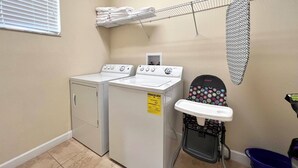 A laundry room with two stacked washers and dryers, a drying rack, and a folding station. - Pp2904 - 6BR House With Pool Near Disney Parks (Kissimmee)