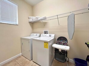 A laundry room with two stacked washers and dryers, a drying rack, and a folding station. - Pp2904 - 6BR House With Pool Near Disney Parks (Kissimmee)