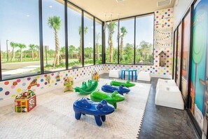 A children's play area with large windows, colorful polka dot walls, and a view of palm trees. - Mvv7485 - 3BR House Near Disney With Hot Tub (Kissimmee)